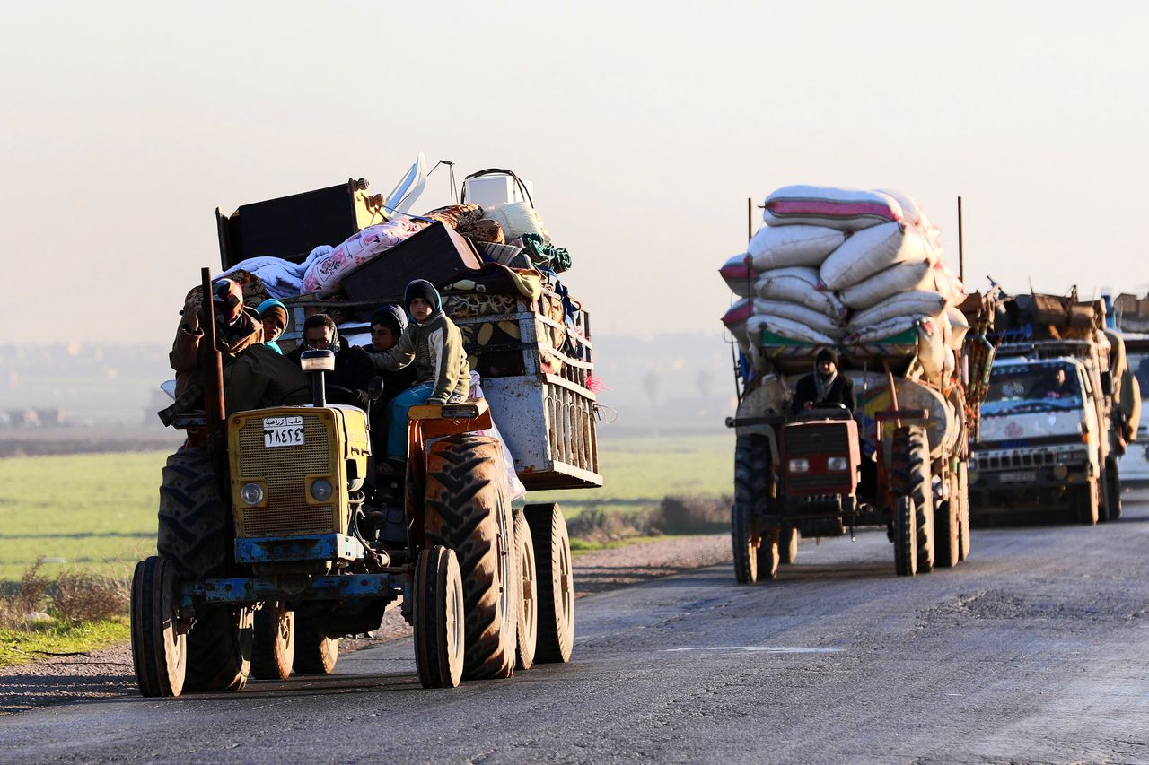 Syriërs die gevlucht zijn voor de gevechten in Idlib op de weg bij Saraqib.