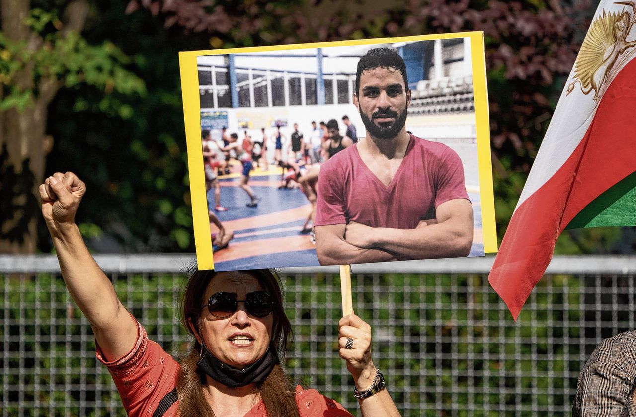 Een Iraanse protesteert half september in Berlijn met het portret van oud-worstelaar Navid Afkari tegen diens executie in Iran.