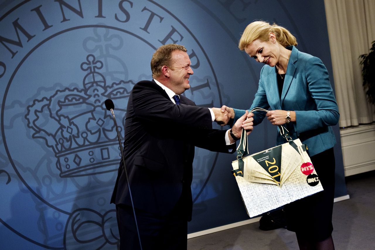 Lars Løkke Rasmussen en zijn opvolger als premier, Helle Thorning-Schmidt, wisselen presentjes uit.