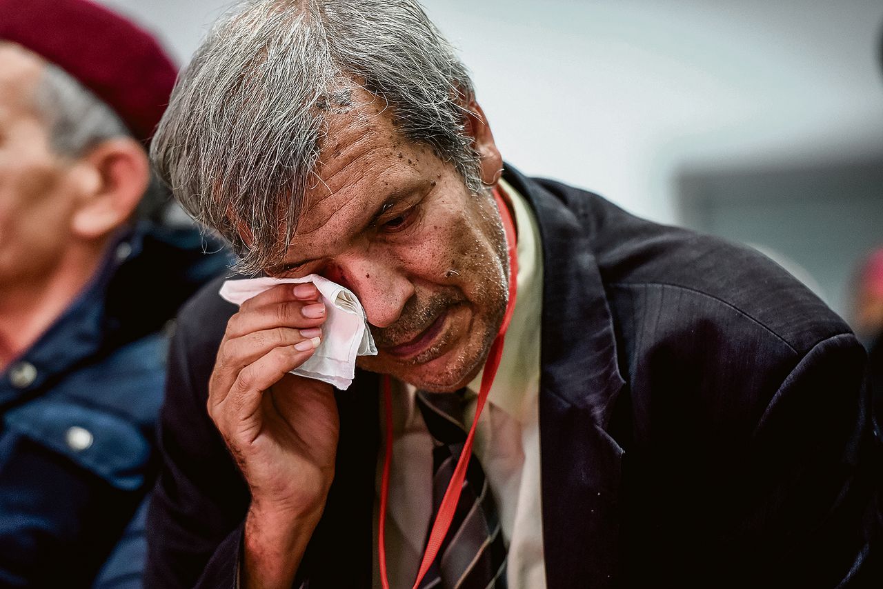 Een man veegt zijn tranen weg terwijl hij met familieleden van slachtoffers van het Tunesische regime een live-uitzending bekijkt van de getuigenissen van de slachtoffers. Deze getuigenissen, gedaan voor de waarheidscommissie, werden op televisie uitgezonden.