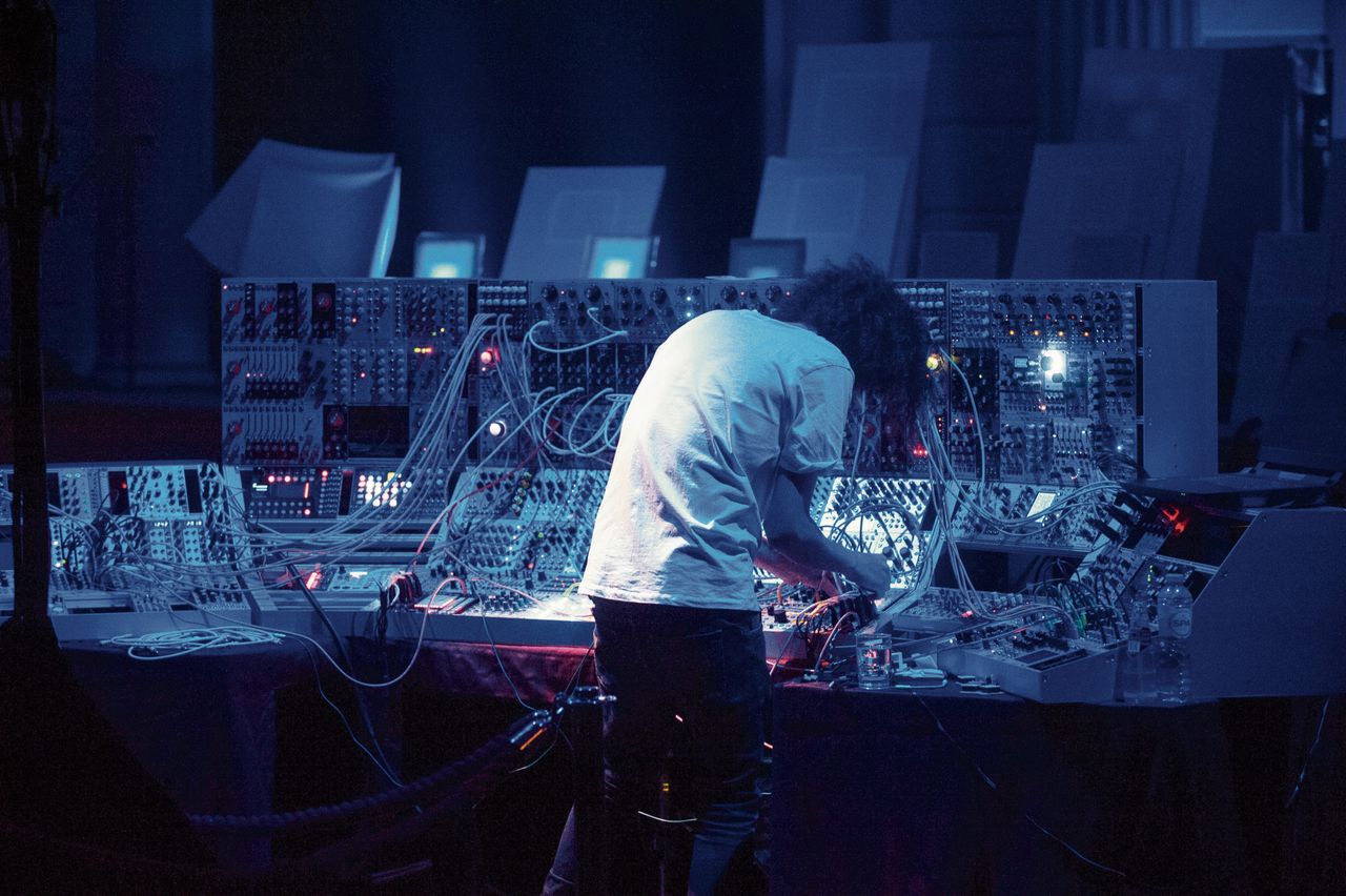 Colin Benders voor zijn muur van modulaire synthesizers.