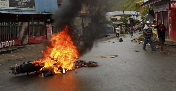Een motor staat in brand, in de Indonesische provincie Jayapura. De afgelopen week was het onrustig nadat een activist is doodgeschoten.