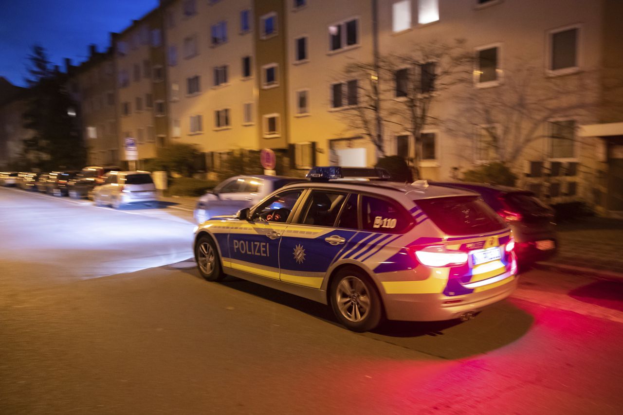 Een politiewagen patrouilleert vrijdagavond in de Neurenbergse wijk waar de steekpartijen plaatsvonden.