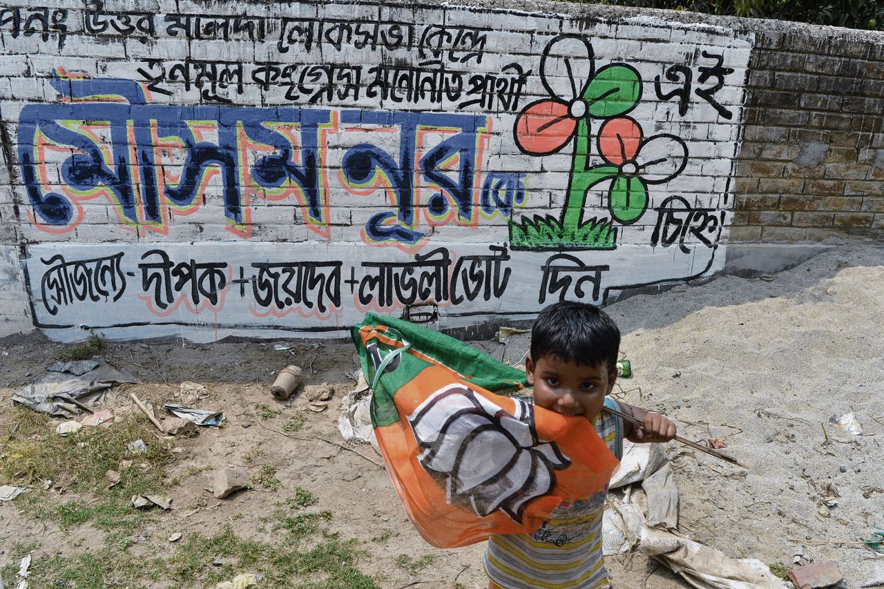 Een jongetje in West-Bengalen met de vlag van de hindoe-nationalistische BJP van premier Modi.