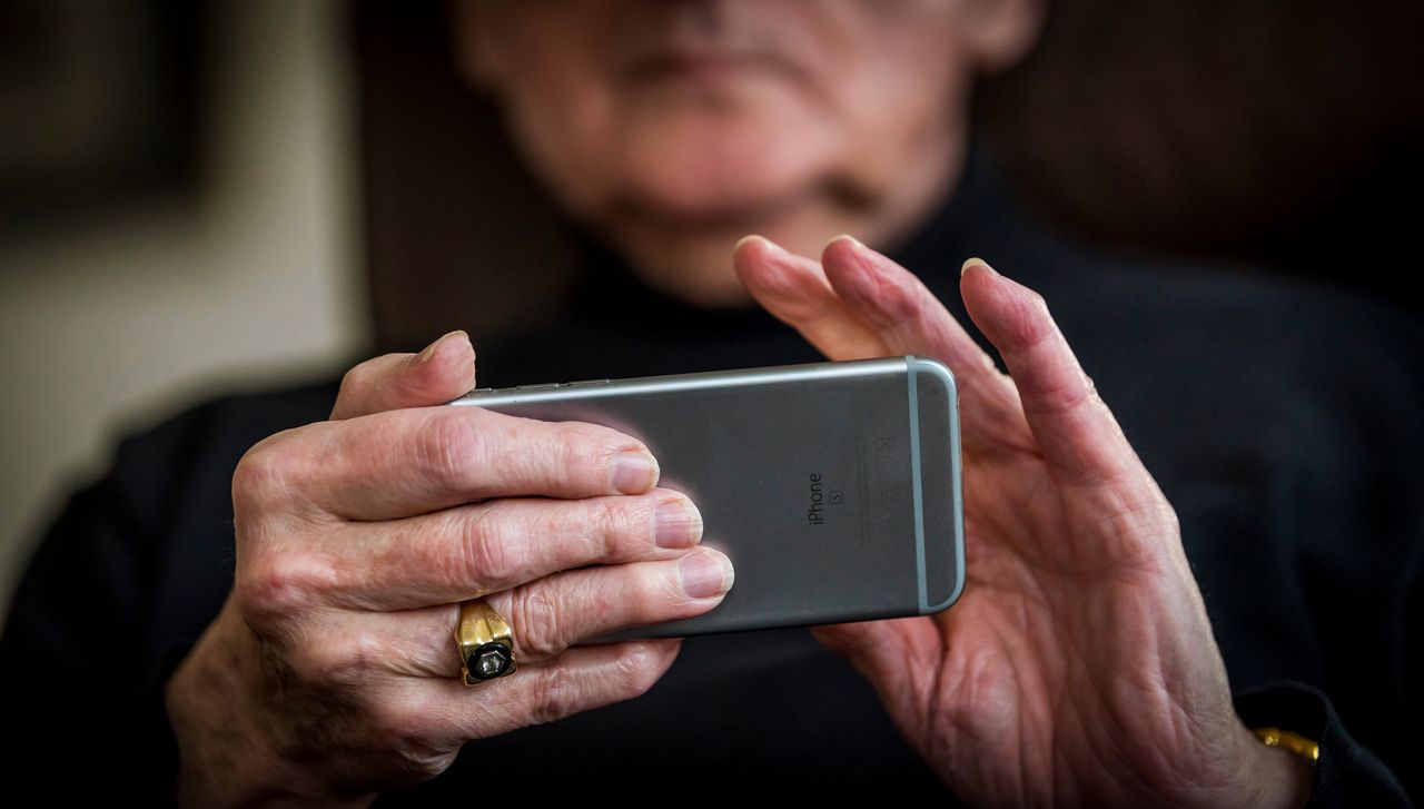Een oudere met een mobiele telefoon.