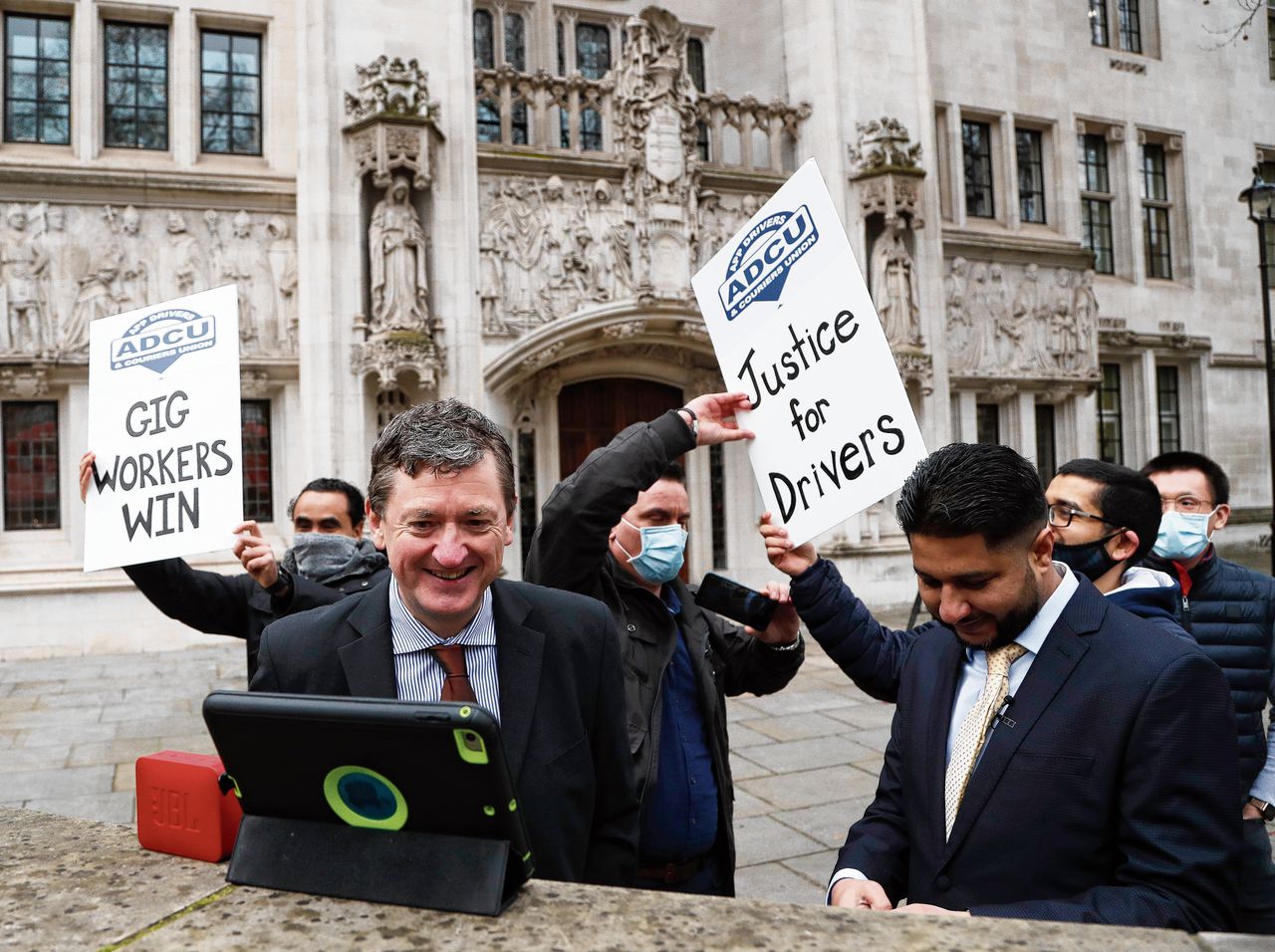 Britse Uber-chauffeurs die zijn aangesloten bij de vakbond ADCU vieren de uitspraak van het Hooggerechtshof in Londen over hun positie als ‘workers’.
