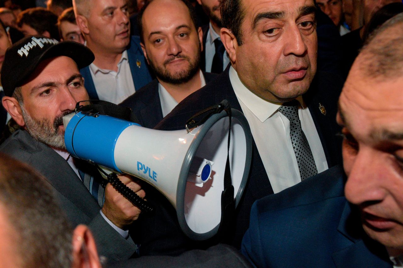 Nikol Pasjinian met een petje en megafoon tijdens de demonstratie bij het parlementsgebouw op 2 oktober.