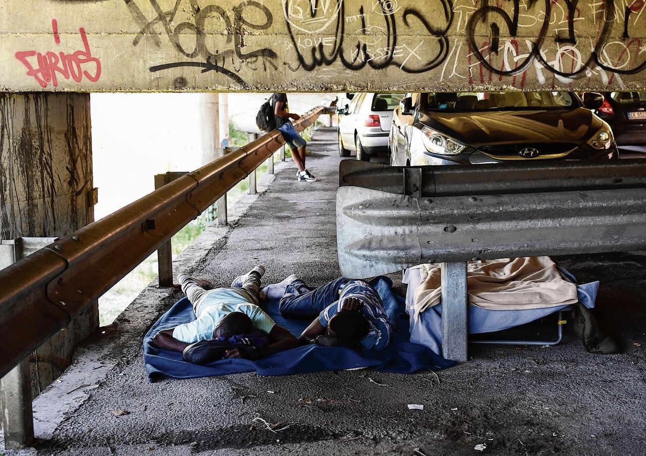 Migranten bivakkeren onder een brug in de Italiaanse grensplaats Ventimiglia.