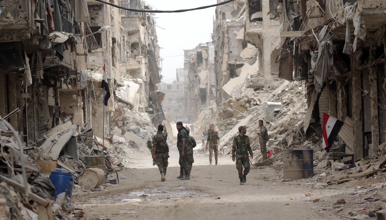 Syrische soldaten op patrouille in Yarmouk, een verstedelijkt Palestijns kamp bij Damascus. Tot 2018 was het gebied in handen van rebellen.