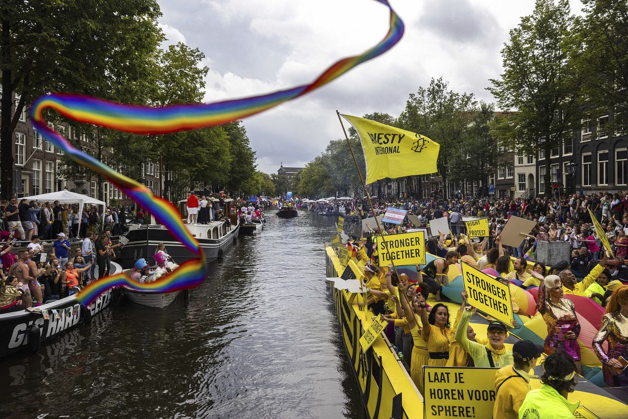 Poncho’s en natte regenboogvlaggen, maar ondanks regen toch veel bezoekers bij Canal Parade 