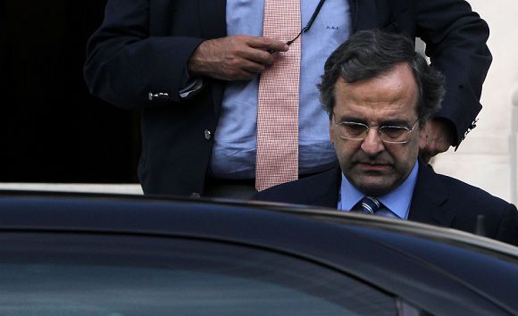 Caption: Greek Prime Minister Antonis Samaras leaves Maximou mansion after a meeting with Greek Socialist leader Evangelos Venizelos and Democratic Left wing party Fotis Kouvelis, in Athens on August 1, 2012. Greece will commit itself to spending cuts worth 11.5 billion euros in the hope of earning more time from its international creditors to enact reforms, senior government officials said today. AFP PHOTO / ANGELOS TZORTZINIS