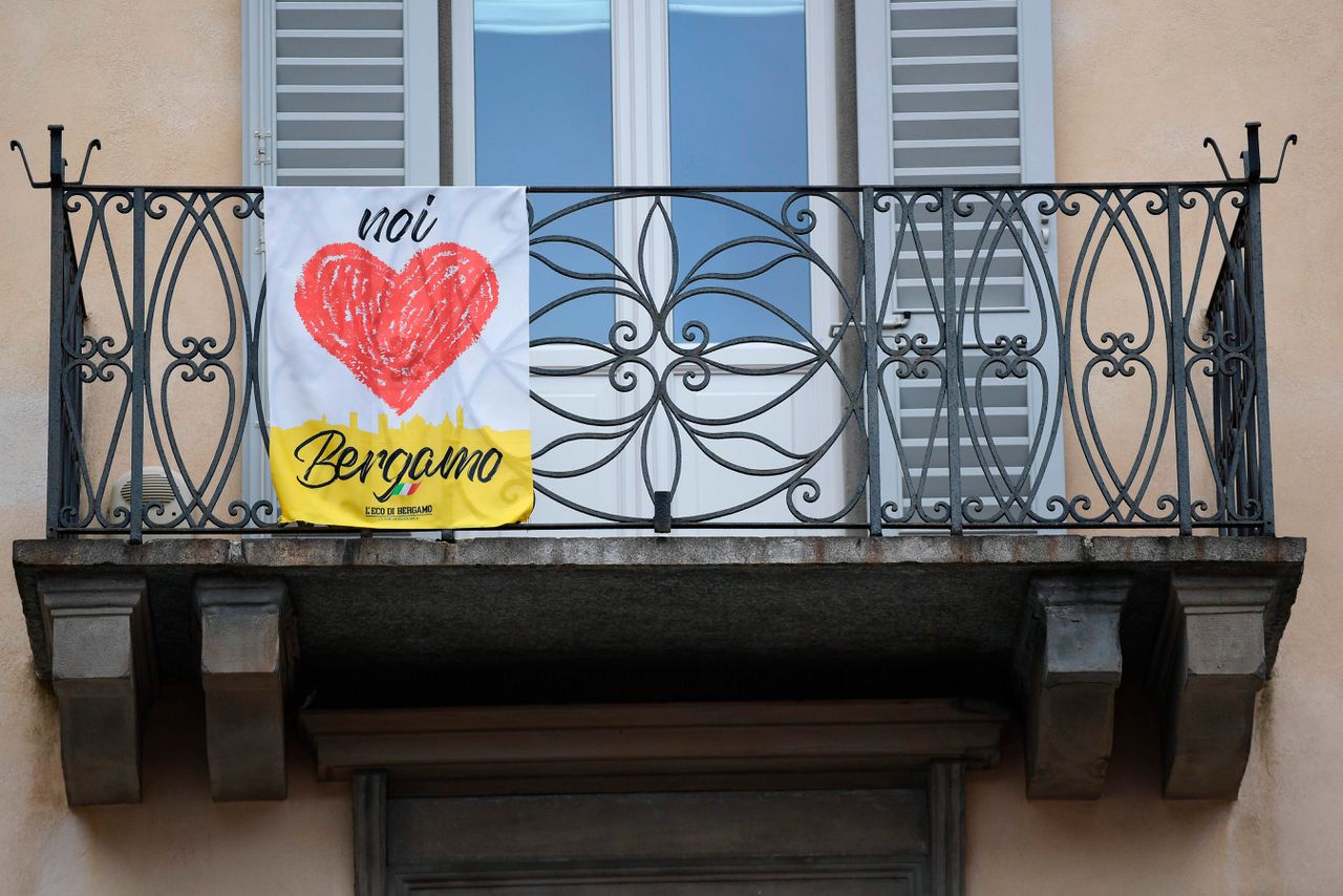 De campagne ‘Wij houden van Bergamo’ van de krant L’Eco di Bergamo aan een balkon in het hoger gelegen oude centrum van de stad.