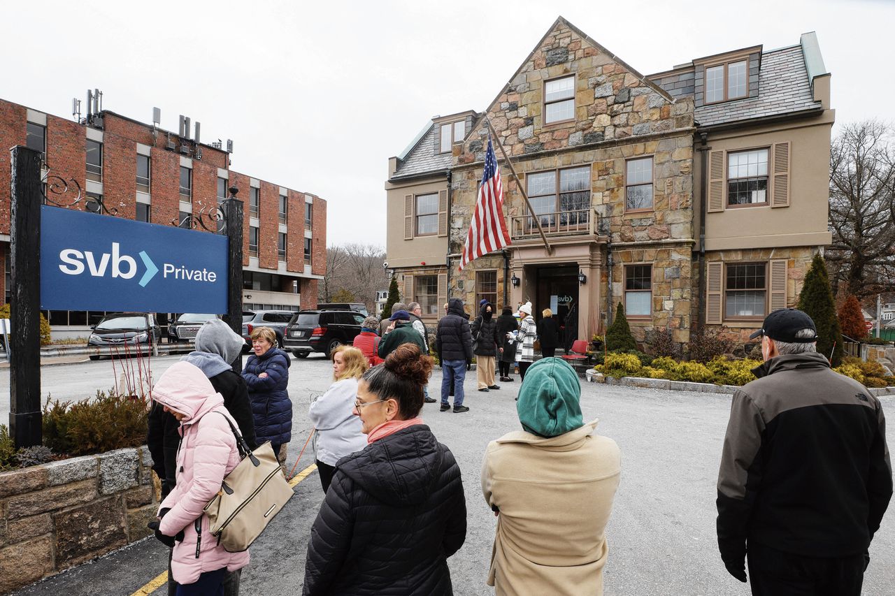 Klanten staan maandag 13 maart in de rij voor een filiaal van Silicon Valley Bank in Massachusetts. Het faillissement van de bank veroorzaakte grote onrust in de bankwereld.