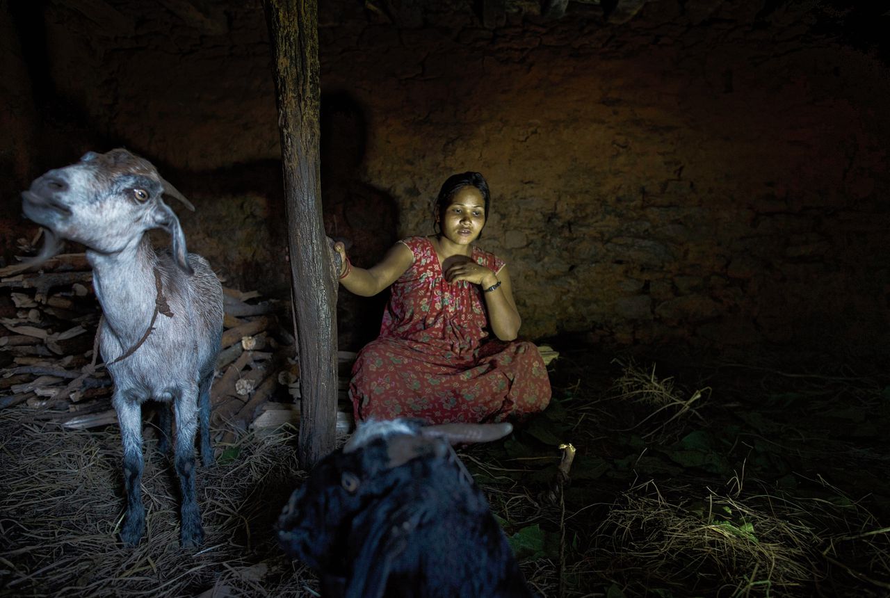Jonge vrouw in het district Achham in Nepal in het schuurtje waar ze slaapt als ze ongesteld is.