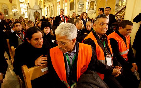 Caption: A Syrian woman, left, speaks with an Arab league observer, right, who attends with other observers a mass prayer for the people and army soldiers who were killed during the violence around the country, at the Holy Cross Church, in Damascus, Syria, on Monday Jan. 9, 2012. Thousands of Syrians attended special prayers held in Damascus for the more than 5,000 people killed since the uprising against President Bashar Assad's regime began in March. The prayers was attended by Christian and Muslim religious leaders.(AP Photo/Muzaffar Salman)