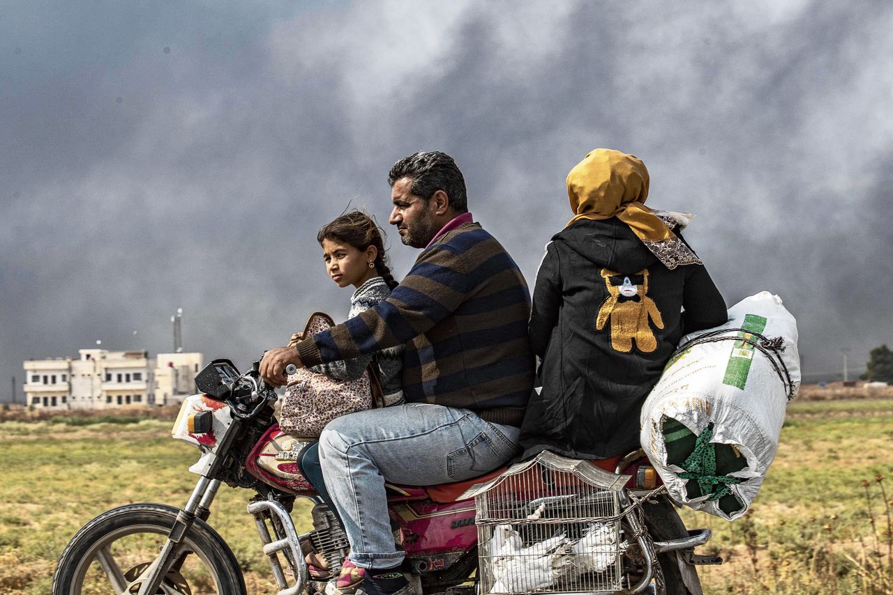 Syrische familie ontvlucht Ras al-Ain, op de grens met Turkije, waar zondag de Koerdische SDF zich uit terugtrokken.