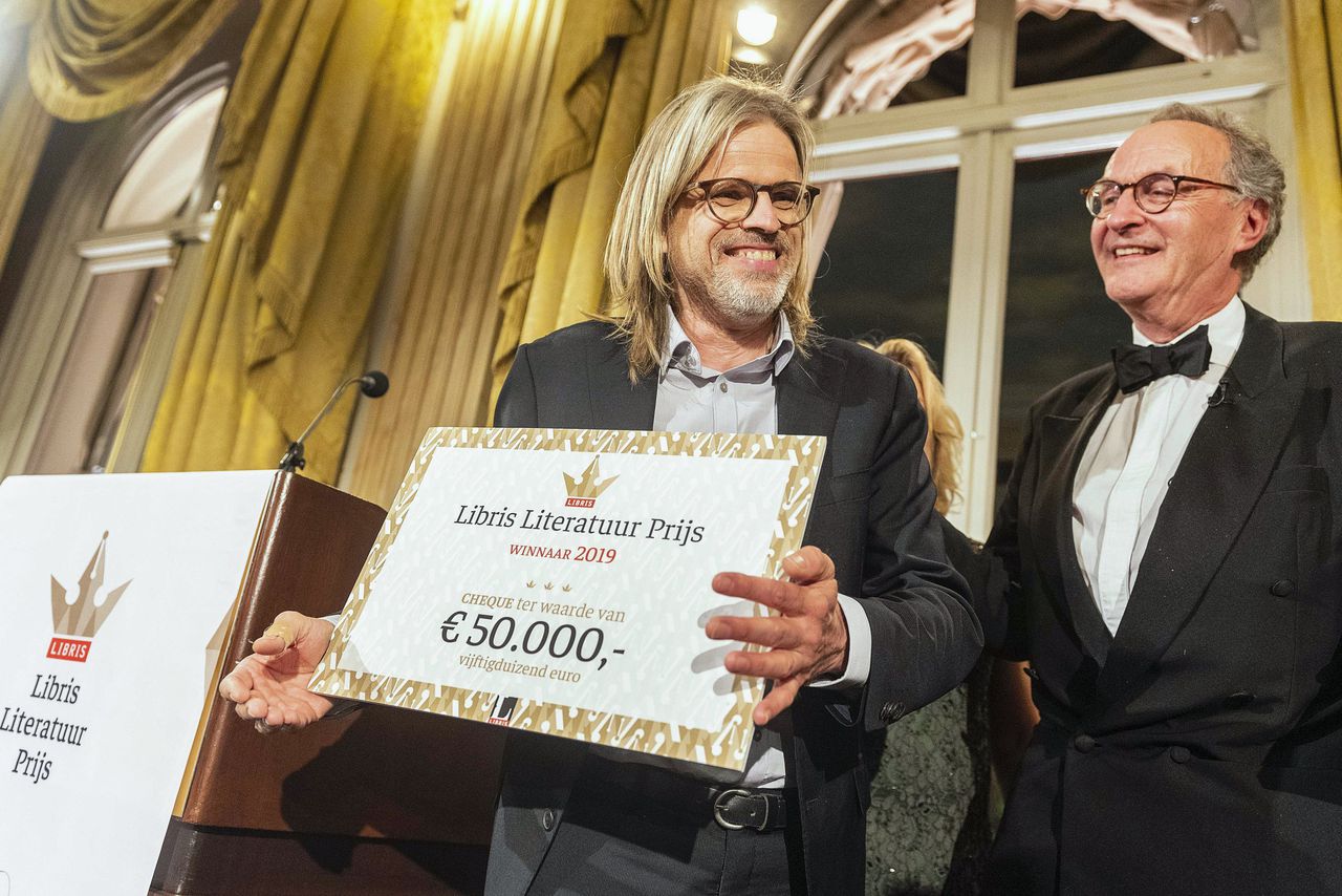 Rob van Essen ontvangt uit handen van Alexander Rinnooy Kan de Libris Literatuur Prijs 2019 voor zijn boek De Goede Zoon.