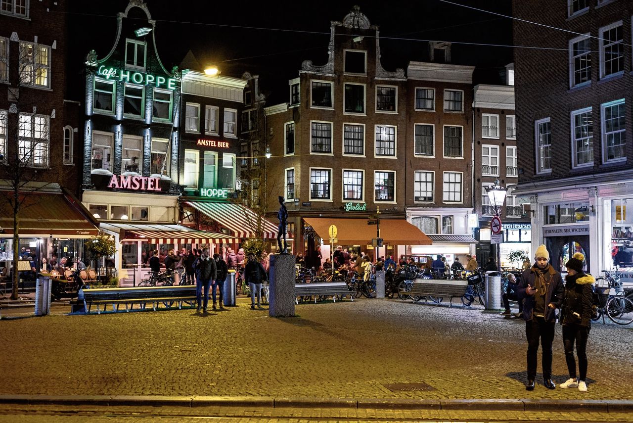 Drukte rond de Heisteeg aan het Spui in Amsterdam op vrijdagavond. Links café Hoppe, rechts van het steegje Café de Zwart.