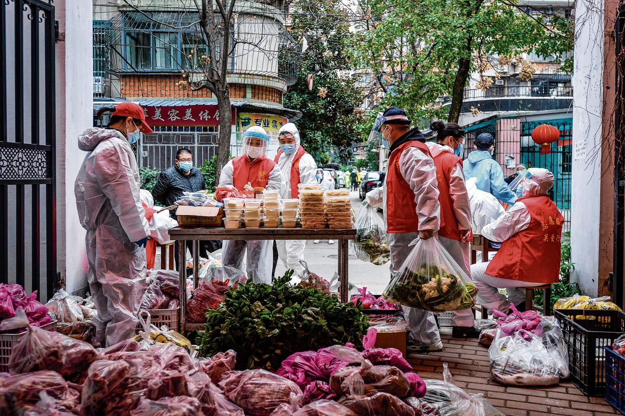 Vrijwilligers delen voedsel uit dat bewoners in Wuhan, in China, hebben besteld.