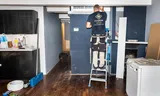 Een Installateur sluit een airco aan in een historisch pand in het centrum van Amsterdam. 