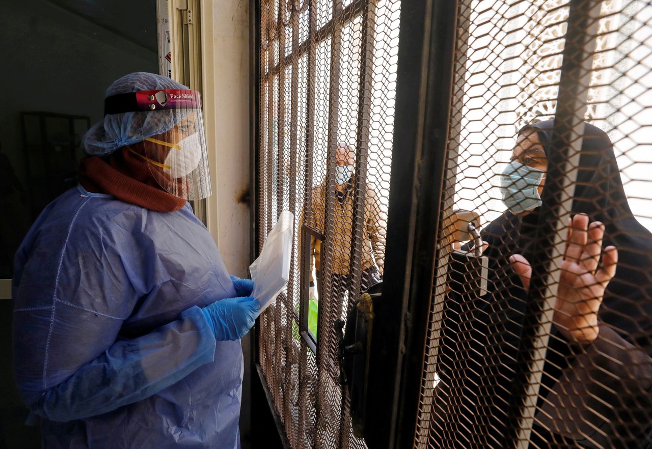 Een vrouw komt medicijnen ophalen bij een medisch centrum in Caïro. Veel ziekenhuizen, klinieken en zorgcentra zijn overbelast aan het raken.