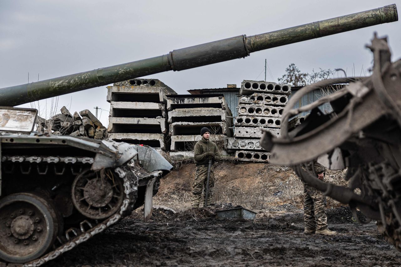 Een Oekraïense militair staat eind december bij tanks op een onbekende plaats in het oosten van Oekraïne.