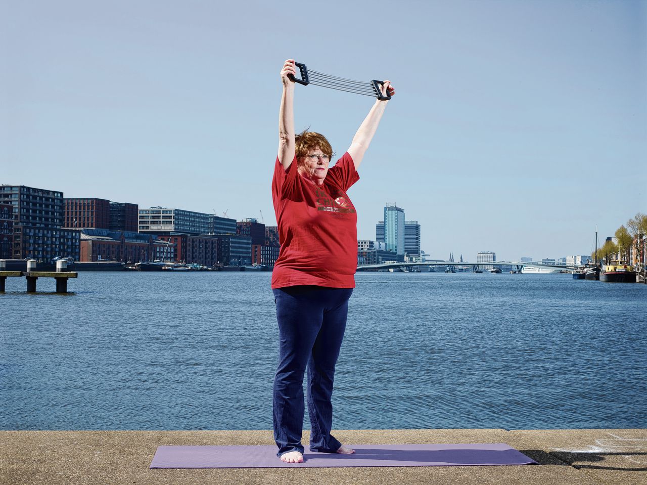 Arina Angerman doet, vlak bij haar huis in Amsterdam, haar oefeningen. „Zonder beweging houd ik mijn gewicht niet constant."