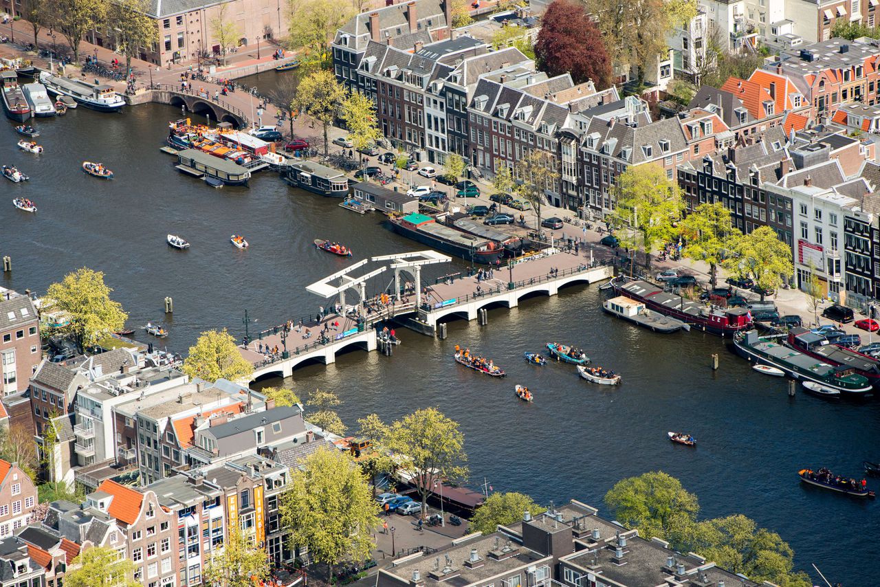 Luchtfoto van boten die varen door de Amstel tijdens de viering van Koningsdag in de hoofdstad.