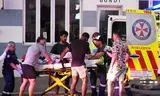Hulpverleners dragen een slachtoffer in een ambulance na de aanslag op Bondi Beach.