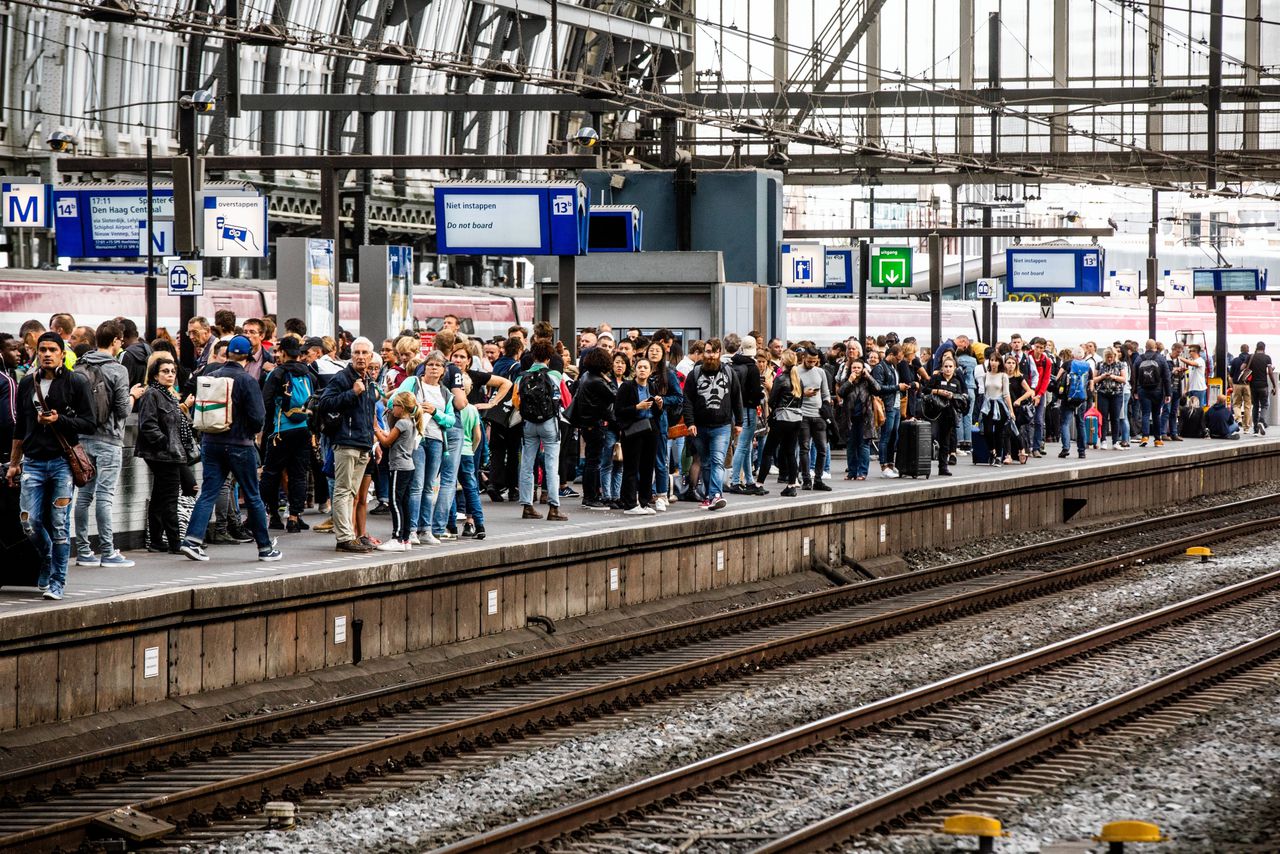 Reizigers wachten op de trein op Amsterdam Centraal.