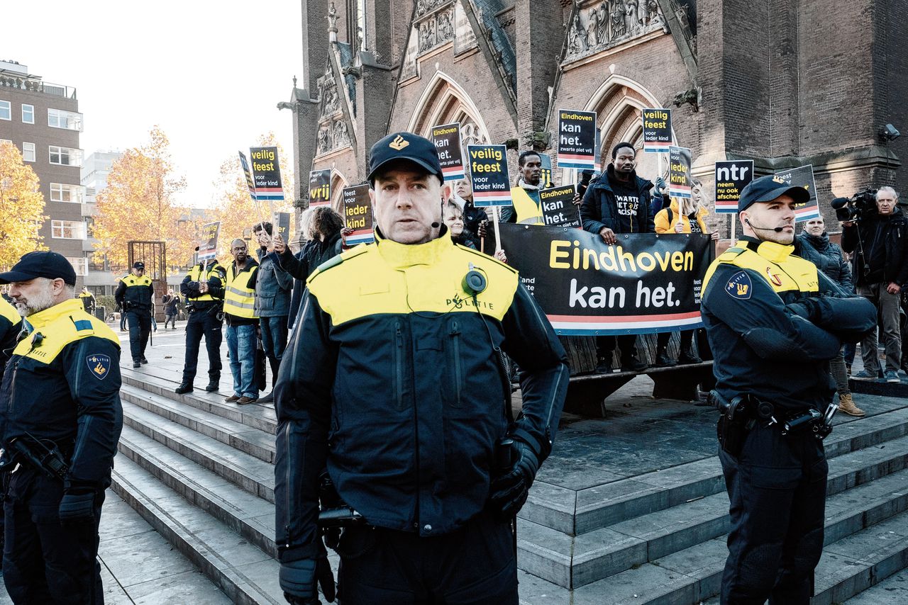 Politieagenten beschermen demonstranten van Kick Out Zwarte Piet bij de intocht van Sinterklaas in Eindhoven.