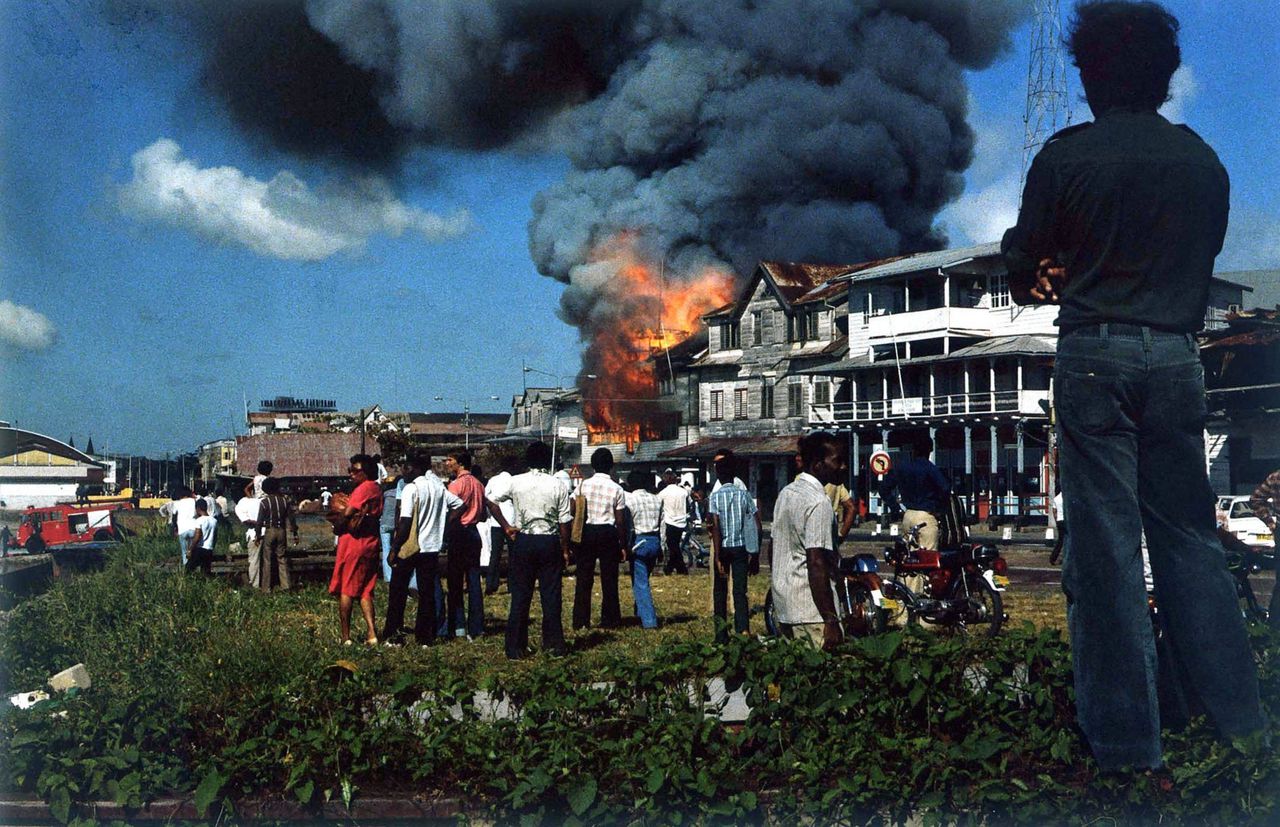 De staatsgreep in Suriname in 1980. Omstanders kijken toe hoe het politiebureau uitbrandt in Paramaribo.