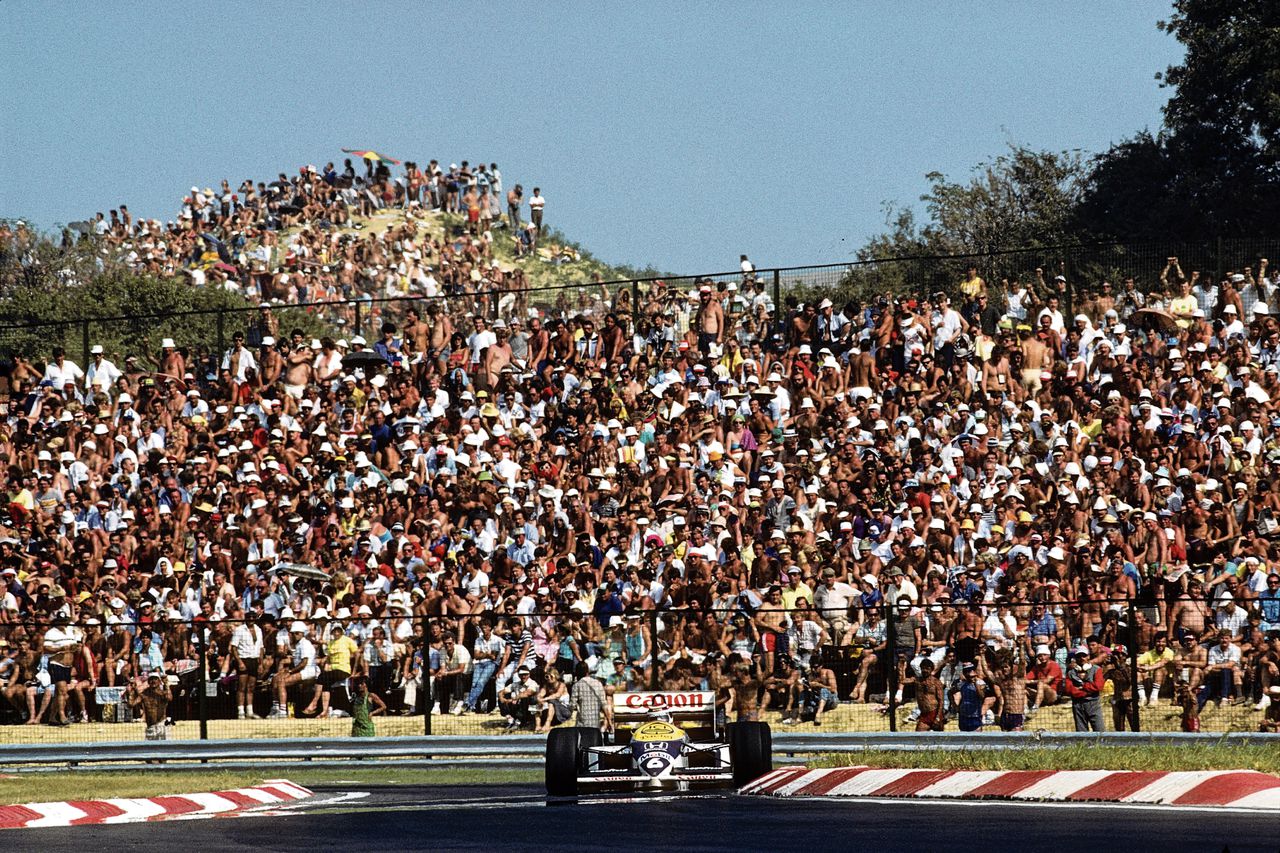 Nelson Piquet van Williams-Honda wint de eerste GP in Hongarije op 10 augustus 1986. Fans kijken massaal naar de zege van de Braziliaan.
