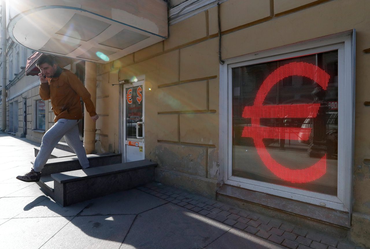 Op een elektronisch bord aan de muur van een wisselkantoor in Sint Petersburg wordt de valutakoers getoond.