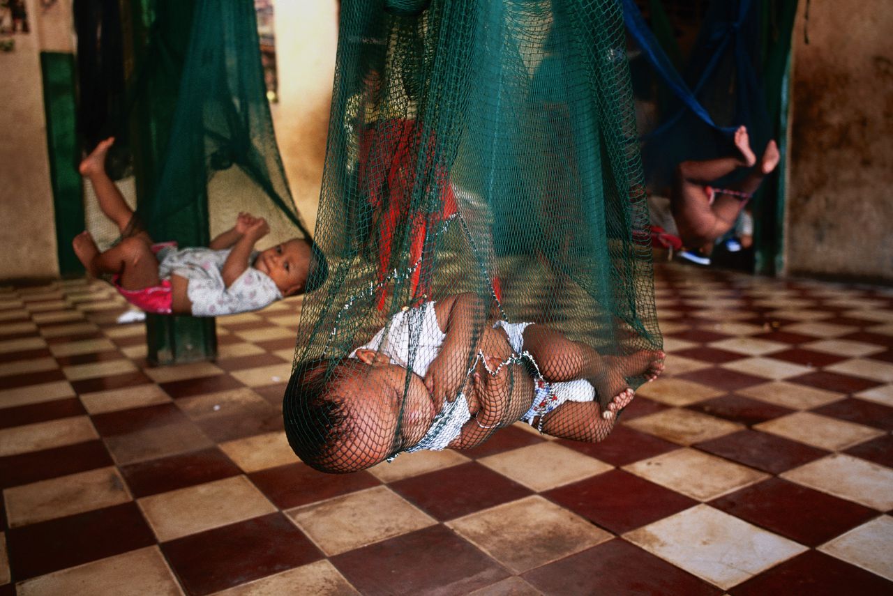 In weeshuis Chea Sim in Siem Reap worden baby's en peuters in hangmatten geplaatst, zodat ze niet in de weg liggen.