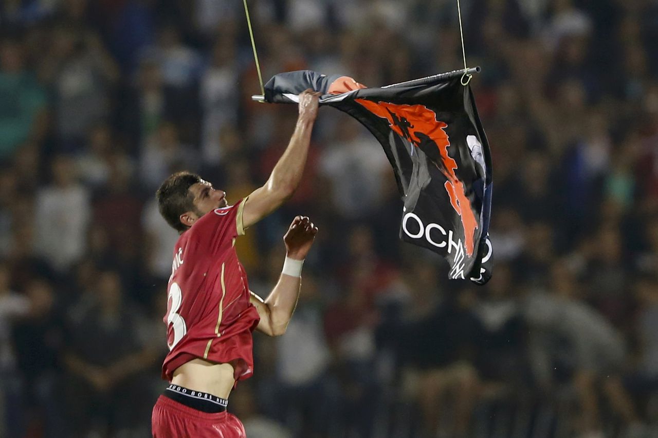 Serviër Stefan Mitrovic pakt de vlag van de drone tijdens het EK-kwalificatieduel met Albanië.