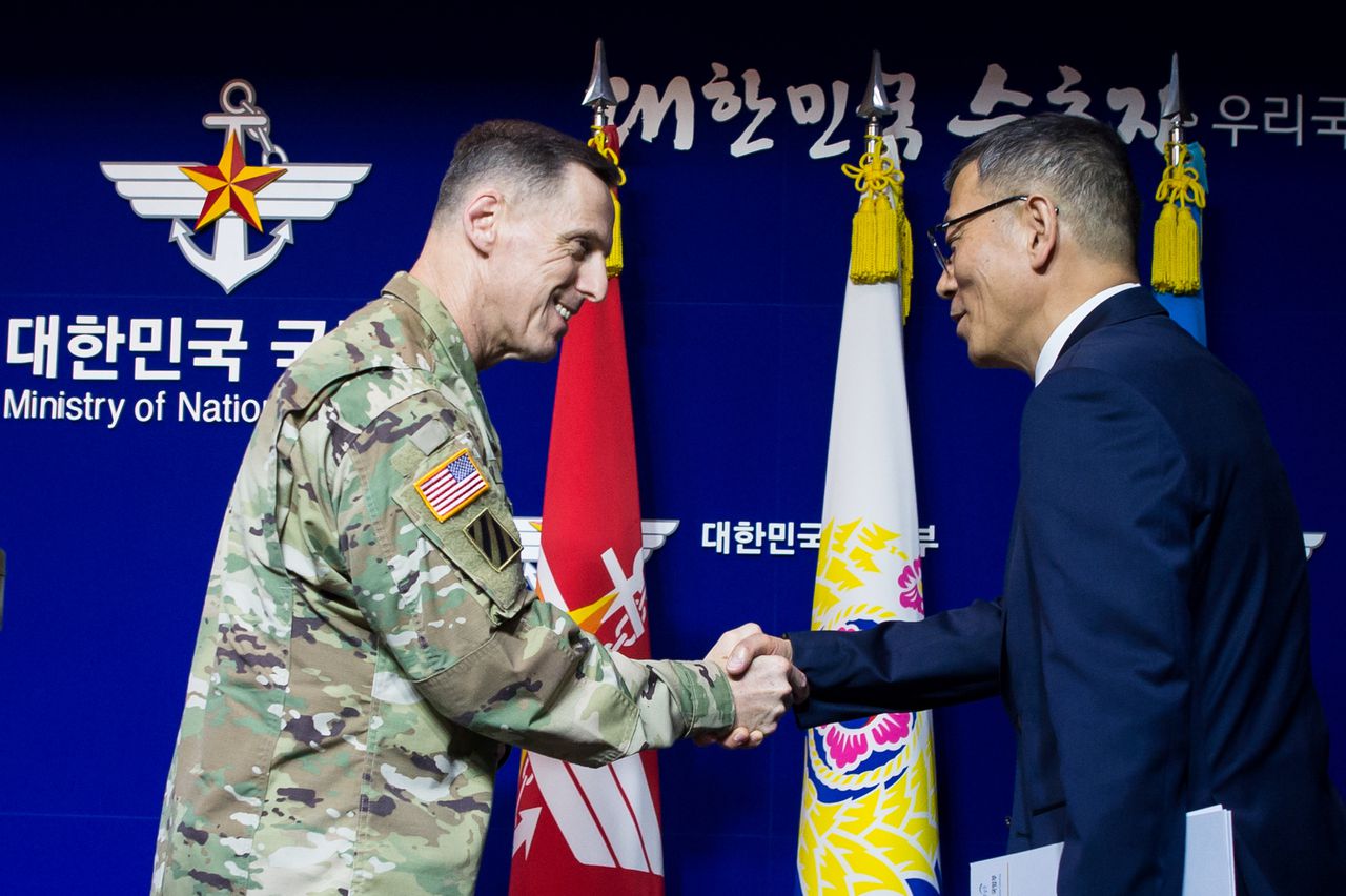 De Zuid-Koreaanse onderminister van Defensie Yoo Jeh-seung schudt de hand van de Amerikaanse luitenant-generaal Thomas Vandal na een persconferentie waarop een akkoord over de plaatsing van THAAD werd aangekondigd.