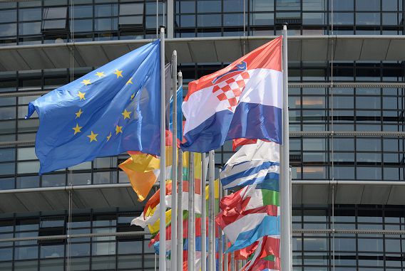 De Europese vlag wappert samen met die van individuele lidstaten buiten het Europees Parlement in Straatsburg.