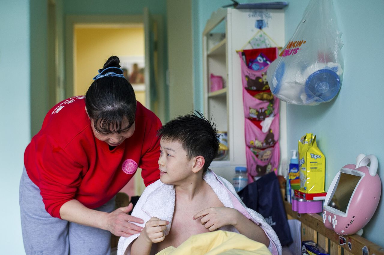 Li (50) wast Xiao Jun (10) in het medisch centrum voor kinderen in Shanghai.