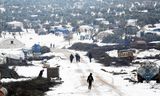 Boven: Syriërs op de vlucht in Idlib.  Honderdduizenden vluchtelingen komen terecht in geïmproviseerde kampen aan de grens met Turkije. Beneden: een kamp deze maand bij de stad Azaz bedekt met sneeuw.