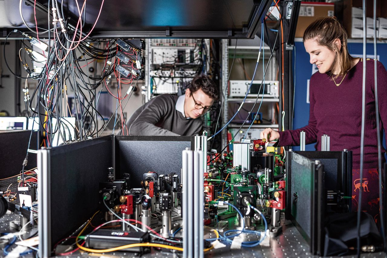 Sophie Hermans en haar collega Matteo Pompili bij de chip genaamd Alice in het laboratorium van QuTech in Delft.