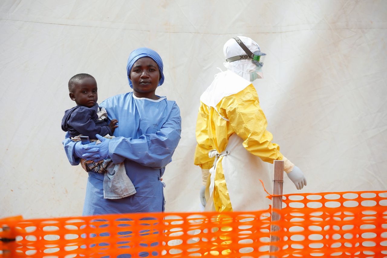 De vrouw in het blauw heeft haar ebolabesmetting overleefd en verpleegt nu in het oosten van Congo baby's die het virus hebben.