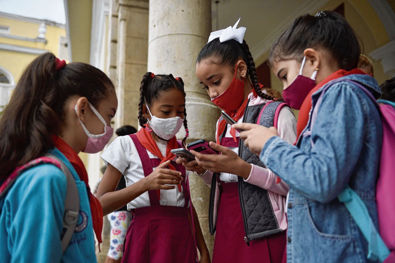 Kinderen met smartphone op een school in Cuba. Miljoenen gebruikers over de hele wereld staan voor het dilemma: op Whatsapp blijven of niet?