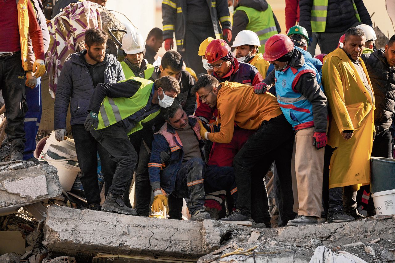 Reddingswerkers in de miljoenenstad Adana helpen een man uit het puin.