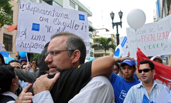 Handout picture released by Ecuadorean newspaper El Universo, of Cesar as he is embraced surrounded by a crowd of employees demonstrating in his favour outside the Supreme Court in Guayaquil, Ecuador, on July 19, 2011. A judge in Ecuador convicted on July 20, 2011 three newspaper executives, Nicolas, Carlos and Cesar Perez, and an editor, Emilio Palacio, of libel, sentenced them to three-year jail terms and handed a 40-million-dollar damages award to President Rafael Correa. AFP PHOTO/EL UNIVERSO - Jorge Guzman
