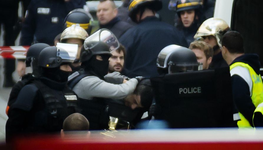 De Franse politie arresteert een verdachte tijdens een politieactie tegen terreurverdachten in de Parijse voorstad Saint-Denis, een paar dagen na de aanslagen in Parijs.