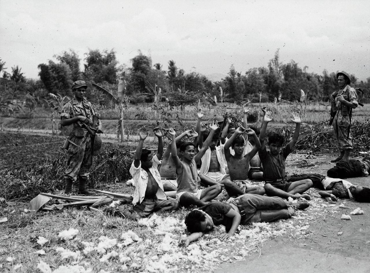 KNIL-soldaten op Malang bij gevangengenomen en gedode Indonesische strijders tijdens de Eerste Politionele Actie, 24 juli 1947.
