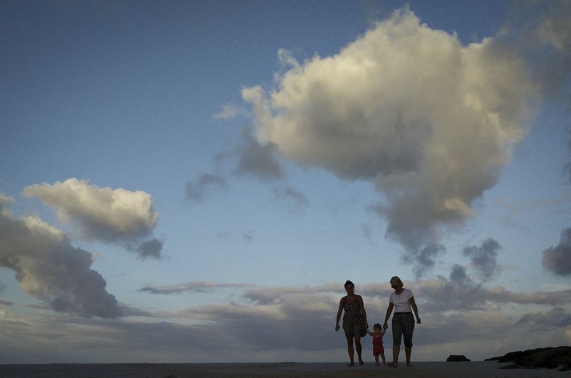 Vrouwen en een kind lopen over het strand van Marineland in Florida.