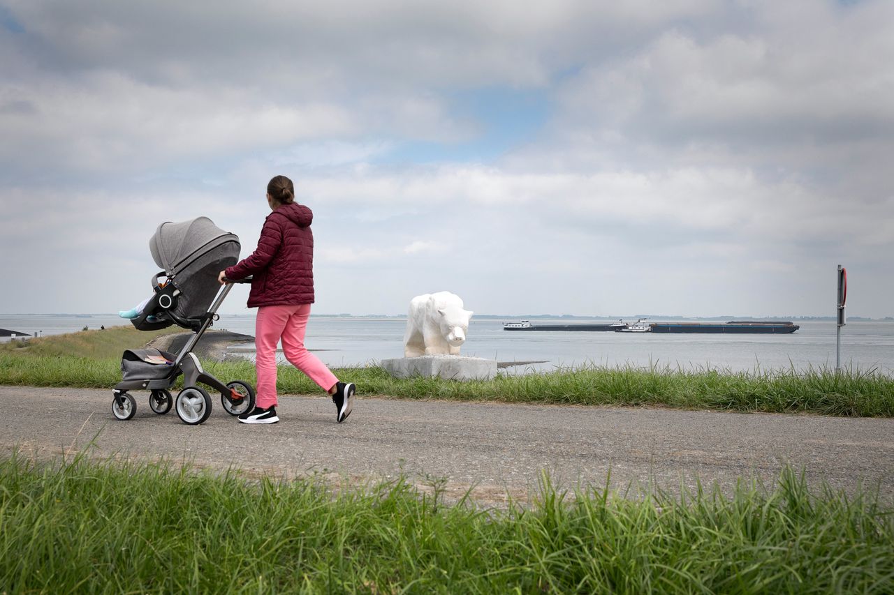 Een moeder met kind loopt langs het kanaal bij Terneuzen.