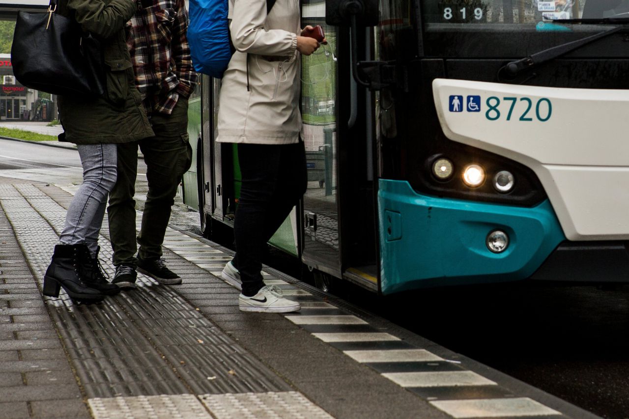 Passagiers stappen in een bus van vervoersmaatschappij Arriva bij een bushalte.